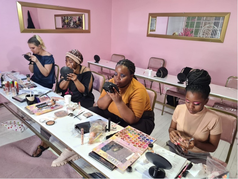 Learners practising make-up techniques in a training classroom