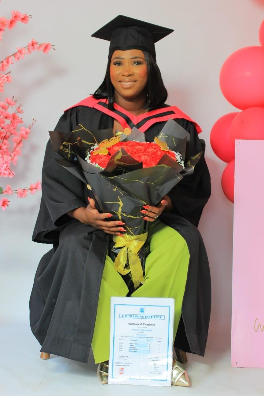 Graduate celebrating with flowers and a certificate